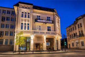 a large white building with a sign on it at Corner House in Lovech