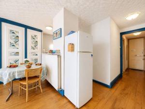 a room with a white refrigerator and a table at Azur des jardins in Annonay
