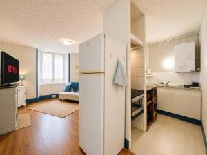 a kitchen with a white refrigerator in a room at Azur des jardins in Annonay