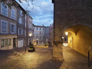 an alley with an archway in a city at night at Azur des jardins in Annonay