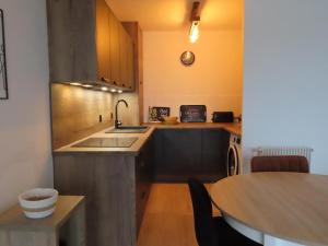 a kitchen with a sink and a table with a tableablish at Le port in Perros-Guirec