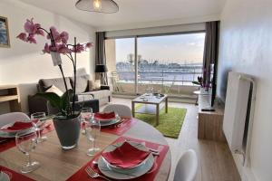 a living room with a dining room table with a view at Le port in Perros-Guirec