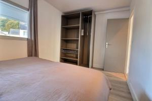 a bedroom with a bed and a window and a closet at Le port in Perros-Guirec