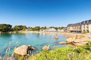 a body of water with a beach and buildings at Le port in Perros-Guirec