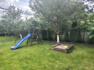 a playground with a slide in a yard at Domek letniskowy w Nadolu nad jeziorem Żarnowieckim in Nadole +22 photos