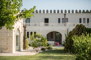 uma casa com um jardim em frente em Le Scuderie - Castello Monaci em Salice Salentino