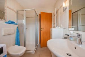 a bathroom with a toilet and a sink and a shower at Lindenstraße Ferienwohnung Anker in Koserow +17 photos