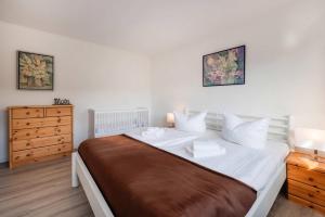 a bedroom with a large bed and a dresser at Lindenstraße Ferienwohnung Anker in Koserow