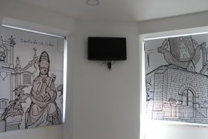 a mural of a statue and a tv on a wall at SeiaVilla - São Pedro in Seia