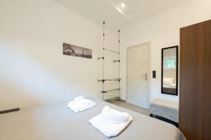 a bedroom with a bed with two towels on it at Luxury Black and White Interior Apartments & Rooftop Terrace in Kalamata +82 photos