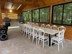 a large dining room with a white table and chairs at Buriani-resort in Tsʼkhvarichamia
