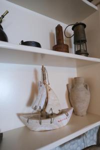 a shelf with a vase and a boat on it at Paradiso in Firopótamos