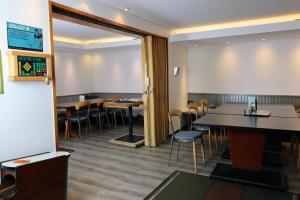 a dining room with tables and chairs and a screen at Hotel & Wirtshaus Hansen in Bergisch Gladbach +87 photos