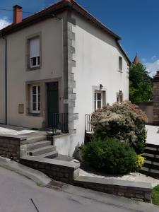 a white house with a green door and stairs at Gîte Bourgeois in Isches