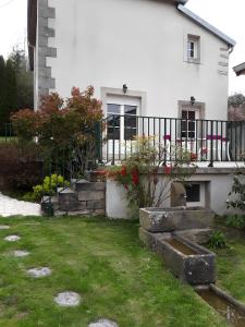 a white house with a balcony and a yard at Gîte Bourgeois in Isches +6 photos