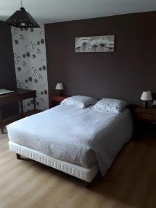 a bedroom with a white bed and two night stands at Gîte Bourgeois in Isches