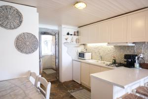 a kitchen with white cabinets and a counter top at Paradiso in Firopótamos