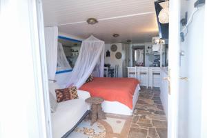 a bedroom with a bed and a couch in a room at Paradiso in Firopótamos