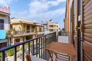 a balcony with a wooden table on a railing at Maison Vivian Rooms in Marzamemi