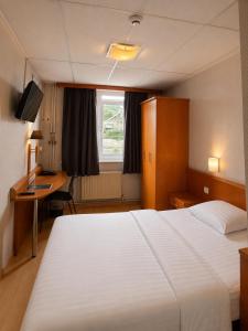 a hotel room with a large bed and a desk at Hôtel de l'Univers Liège in Liège