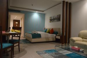 1 dormitorio con cama, mesa y sofá en Markazia Suites, en Beirut