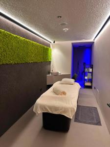a bedroom with a bed and a wall with green plants at Genusshotel Diamant in Naturno