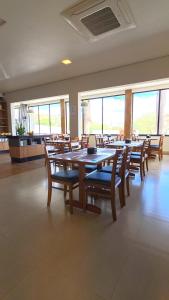 a dining room with a table and chairs and windows at Hotel Planalto 2 in Governador Valadares