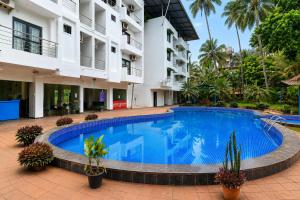a swimming pool in front of a building at Sunlight Stay at Goa in Calangute