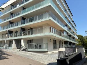 an apartment building with balconies and a bicycle parked outside at Legowisko nad Legą Centrum Olecka in Olecko
