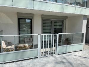 a balcony of a building with a gate and chairs at Legowisko nad Legą Centrum Olecka in Olecko +6 photos