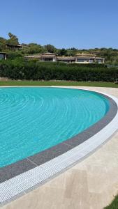 a swimming pool with blue water in a yard at Over The Sea Punta Lada in Porto Rotondo