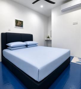 a bedroom with a large white bed with blue floors at CZi BOUTIQUE HOTEL SG SIPUT in Sungai Siput +4 photos