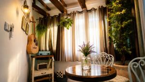 a table with a vase of flowers and a guitar in a room at סתיו בגולן in Qasrîne