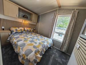 a bedroom with a large bed and a window at Sunnycott Caravan Park in Cowes