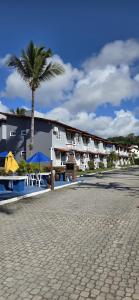a resort with a palm tree and a building at Golden Dolphin Taperapuan Apt 529 in Porto Seguro
