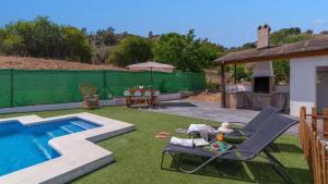 a backyard with a pool and a table and chairs at Villa Andrea Comares in Comares