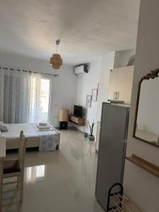 a white room with a bed and a kitchen at Vitamin Sea in Sarandë