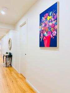 ein Gemälde einer Blumenvase an einer Wand in der Unterkunft Premier Suite with Private Bathroom in Wyndham Vale