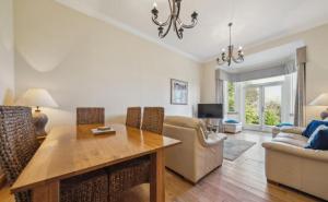 a living room with a dining table and a couch at No 15 Lomond Castle in Balloch