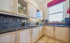 a kitchen with wooden cabinets and a window at No 15 Lomond Castle in Balloch
