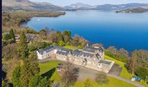 an aerial view of a large house by a lake at No 15 Lomond Castle in Balloch