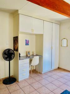 a kitchen with a desk and a chair in a room at The Qs guest suite in Brakpan