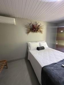 a bedroom with a bed with a plant on the wall at Pousada Casa de Naná in Palmas +15 photos