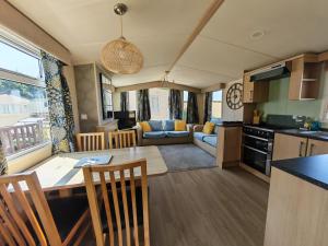 a kitchen and living room with a table and chairs at Sunnycott Caravan Park in Cowes