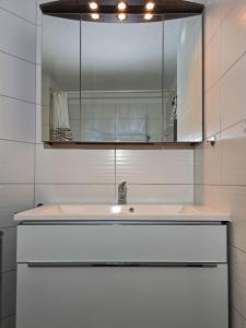 a white bathroom with a sink and a mirror at Onyx - 1 5 Zimmer in Muralto +19 photos