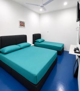 a room with two beds and a tv at CZi BOUTIQUE HOTEL SG SIPUT in Sungai Siput