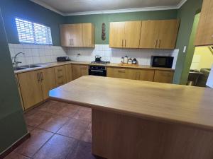 a kitchen with wooden cabinets and a counter top at Kalahari Hotel in Olifantshoek