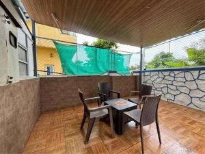a patio with a table and chairs on a balcony at Chikku 4 bhk villa in Lonavala
