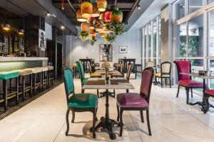 a restaurant with colorful chairs and tables and a bar at ONOMO Hotel Foreshore in Cape Town