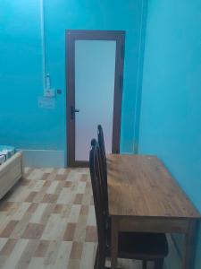 a wooden table and chairs in a room with a door at An Loc Motel in Vĩnh Long